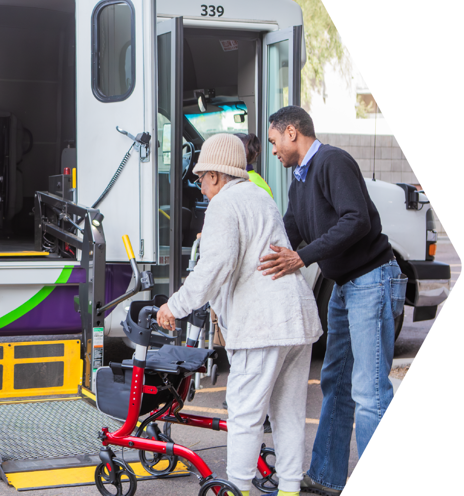 Driver helping a passenger with a walker onto the lift