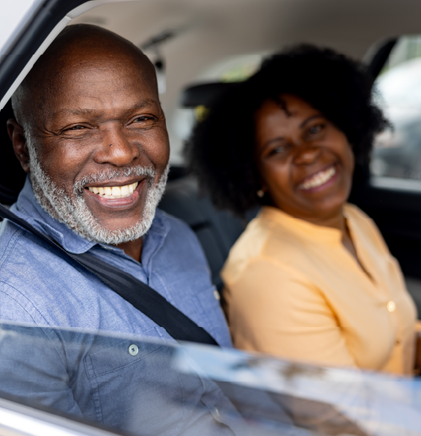 Smiling couple sitting in the back of a car